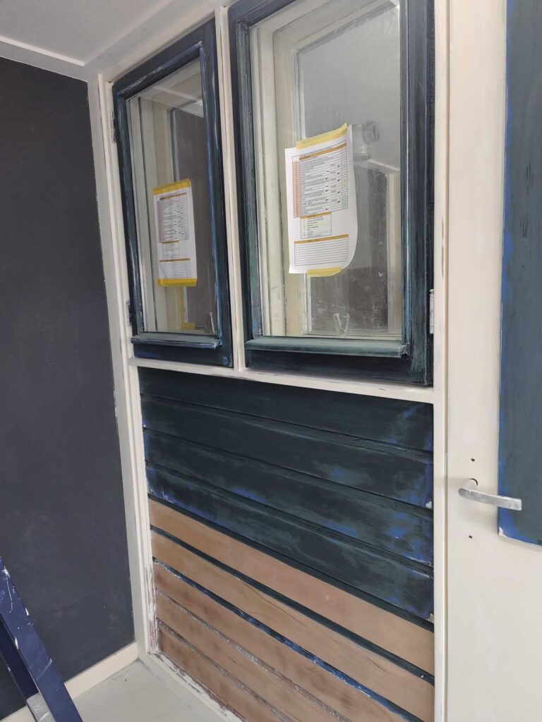 Houten rabatdelen doodgeschuurd tot een matte basis en deels kaal hout in het praktijkhok