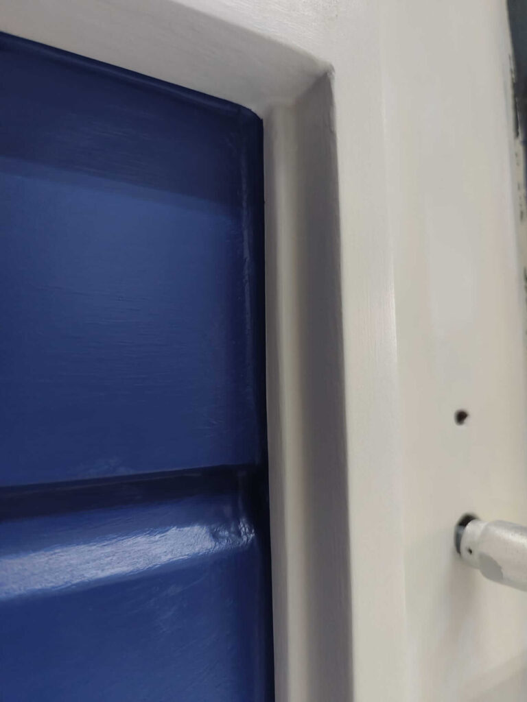 Stuk wit geschilderd kozijn met blauw rabat