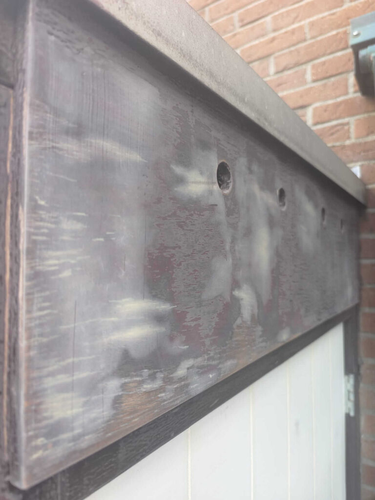 Plaat boven schuurdeur geschuurd en gerepareerd met plamuur